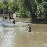 Evacuated families in Sindh wade through floodwaters near Indus river line, Pakistan 2025