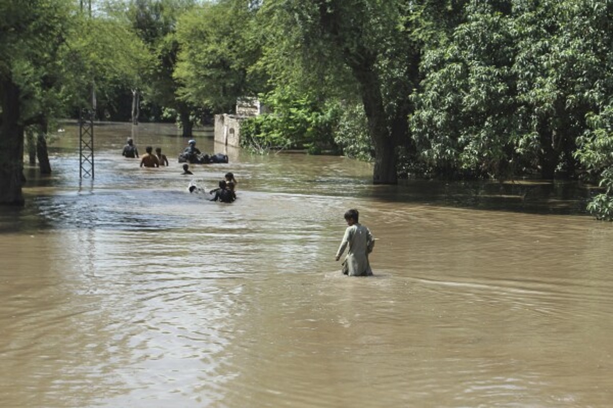 Evacuated families in Sindh wade through floodwaters near Indus river line, Pakistan 2025