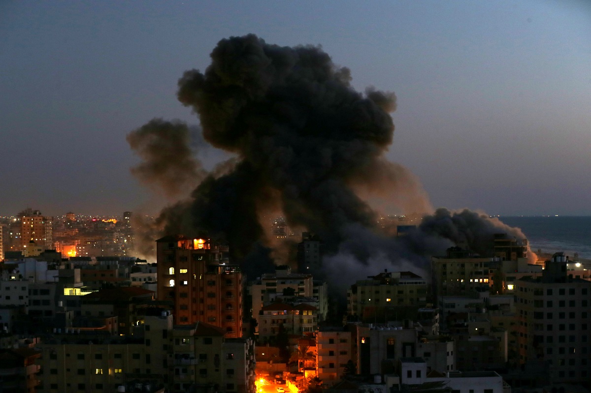 Gaza City skyline with smoke rising after residential high-rise destroyed by Israeli airstrikes