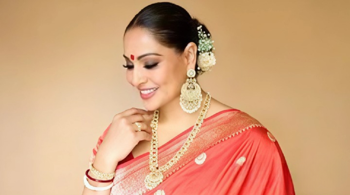 Bipasha Basu viral reel in red saree with toddler tugging at saree during Dussehra celebration.