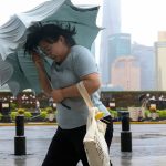 Typhoon Dolphin Chaos: Shanghai Evacuates 1M as Mega-Storm Hits Emergency workers evacuating residents in flooded Shanghai street during Typhoon Dolphin 2026.