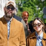 Post Malone Engaged to Christy Lee: Massive Diamond Ring Revealed! Christy Lee showing off a massive diamond engagement ring alongside fiancée Post Malone wearing a cowboy hat.